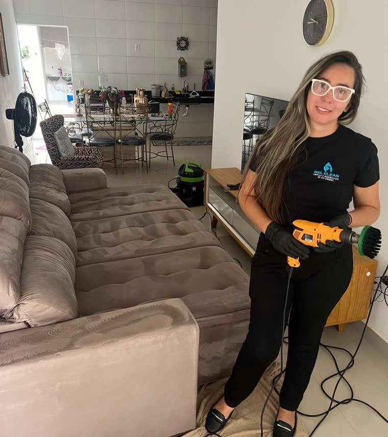 Profissional da BEL Clean higienizando um sofá com escova rotativa